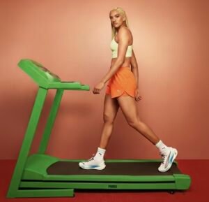 Mergina sportuoja ant bėgimo takelio namų treniruotėje